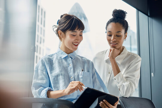 Businesswoman shows a tablet computer to a colleague in the office