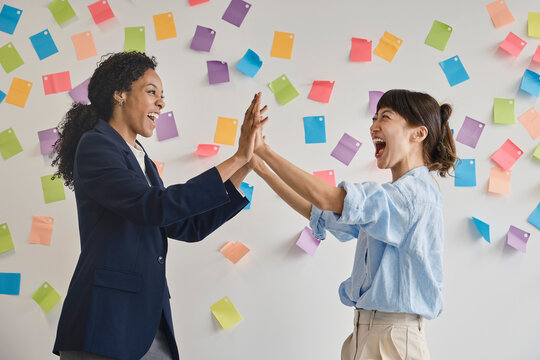 Businesswomen celebrating with high five in London office