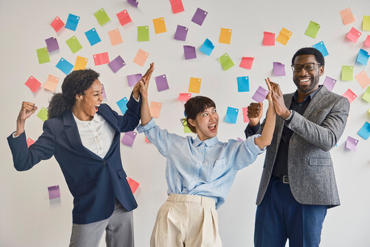Excited business colleagues celebrate success together at the office