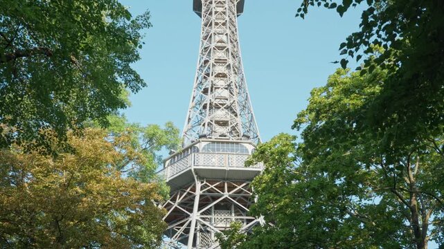 Steel Petrin observation tower stands in a Prague park as a top tourist attraction. Historic Czech landmark represents urban architecture, European travel, and summer vacation sightseeing.