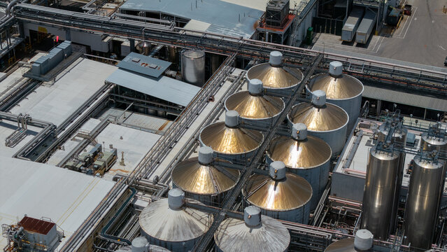 Aerial view of the Tropicana production facility featuring rows of large stainless steel storage tanks and complex industrial piping systems, Bradenton, Florida, United States.