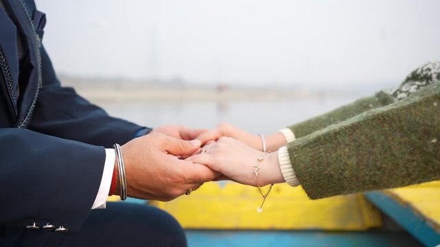 Couple reaching out to hold hands on a boat