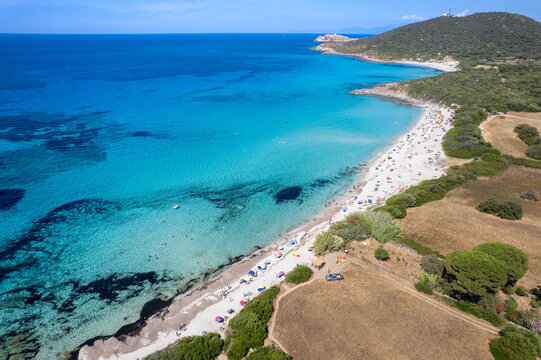 Aerial view of Plage de Ghjunchitu with turquoise waters, sandy shoreline, and Mediterranean vegetation in Corbara, Corse, France.