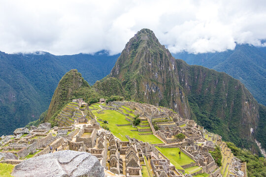 View of the ancient Incan citadel of Machu Picchu set amidst lush green mountain terraces and dramatic Andean peaks in Cusco, Cusco, Peru.