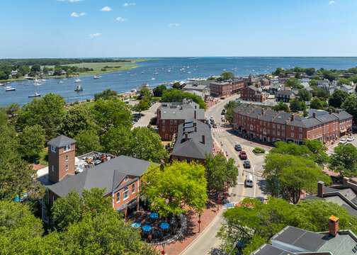 Aerial view of historic brick buildings and the waterfront with boats in the harbor under a clear blue sky in Newburyport, Massachusetts, United States.