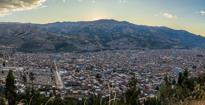 View of the city of Huaraz nestled in a valley surrounded by the Andes mountains under a clear sky at sunset in Ancash, Peru.