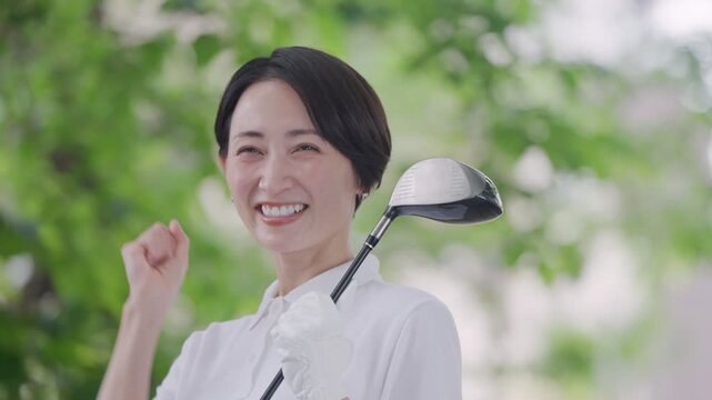 ゴルフをする笑顔の女性