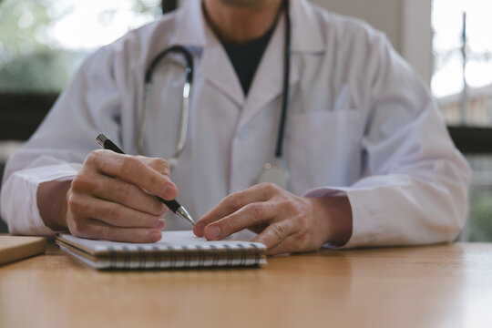 Doctor writing medical notes at a desk with stethoscope in clinic, representing healthcare documentation, patient records, diagnosis, prescription, medical consultation and professional care.