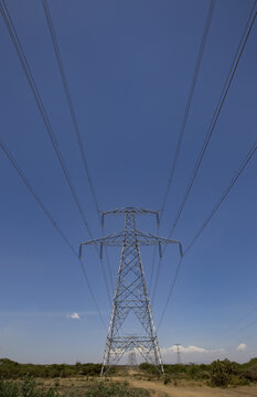 View of the Kenya Power Suswa Substation featuring a large metal electricity pylon with power lines stretching across a clear blue sky in Mirera, Nakuru County, Kenya.