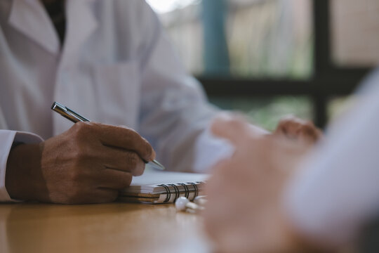 Doctor reviewing medical notes and patient records at a desk with stethoscope, representing healthcare documentation, clinical assessment, diagnosis, consultation and professional medical care.