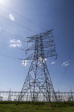 View of Kenya Power Suswa Substation featuring a large steel electricity transmission tower with high-voltage power lines against a clear blue sky in Mirera, Nakuru County, Kenya.