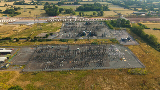 Aerial view of Berkswell Substation featuring electrical infrastructure, power transformers, and switchgear surrounded by rural fields and construction work in Coventry, England, United Kingdom.