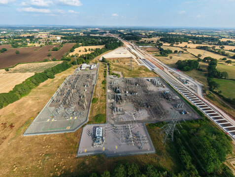 Aerial view of the Berkswell Substation featuring electrical transformers and power lines surrounded by rural fields and construction infrastructure in Coventry, England, United Kingdom.