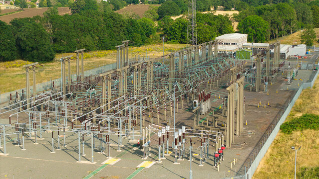 Aerial view of Berkswell Substation featuring electrical infrastructure, transformers, and power lines within a fenced compound surrounded by trees in Coventry, England, United Kingdom.