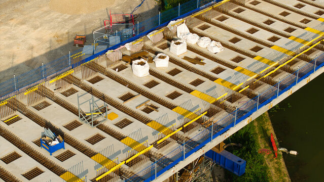 Aerial view of the HS2 railway construction site showing concrete bridge segments, steel reinforcement bars, and construction materials in Long Itchington, England, United Kingdom.