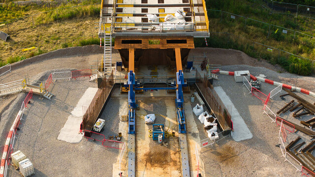 Aerial view of the HS2 railway construction site featuring bridge infrastructure, heavy machinery, and gravel ground in Long Itchington, England, United Kingdom.