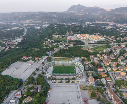 Avellino, Italy - 22 July 2026: Aerial view of Stadio Partenio-Adriano Lombardi surrounded by residential buildings, lush green hills, and a highway in the outskirts of Avellino.