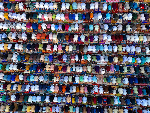Aerial view of a large congregation of people praying in organized rows on colorful prayer mats during a religious gathering in Kushtia, Khulna Division, Bangladesh.