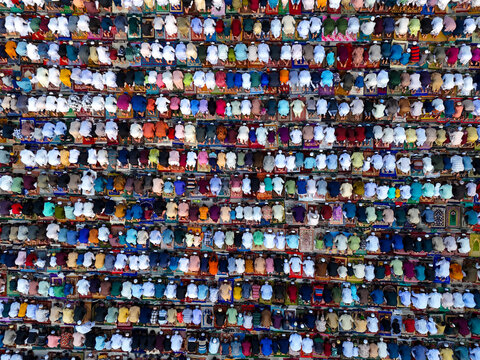 Aerial view of a large congregation of people praying in organized rows on colorful prayer mats during a religious gathering in Kushtia, Khulna Division, Bangladesh.