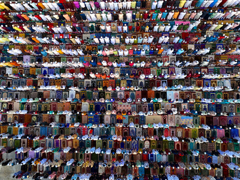 Aerial view of a large crowd of people praying on colorful prayer mats arranged in neat rows in Kushtia, Khulna Division, Bangladesh.