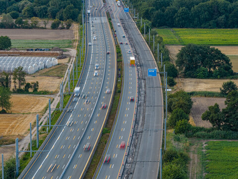 Aerial view of the Teststrecke Oberleitung fur LKW eHighway with overhead power lines for electric trucks, surrounded by agricultural fields and trees in Weiterstadt, Hessen, Germany.