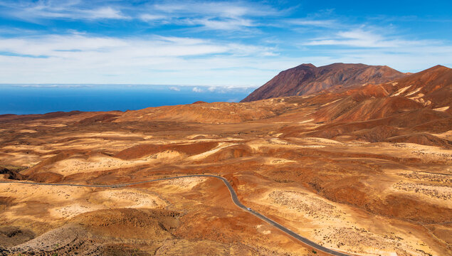 Aerial view of the winding road through the arid volcanic landscape of Santo Antao, with distant ocean views in Tarrafal de Monte Trigo, Porto Novo, Cabo Verde.