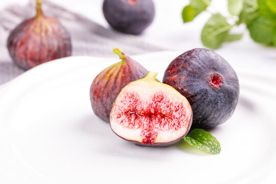 Fresh Red Flesh Figs Cut in Half Showing Seeds and Pulp on White Background