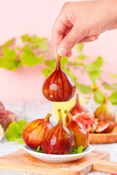 Fresh Red Figs on Wooden Board with Hand Picking Ripe Fruit