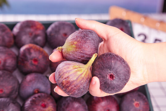 Fresh Purple Figs in Hand at Yunnan Market - Ripe Fruit with Red Flesh and Natural Skin Texture