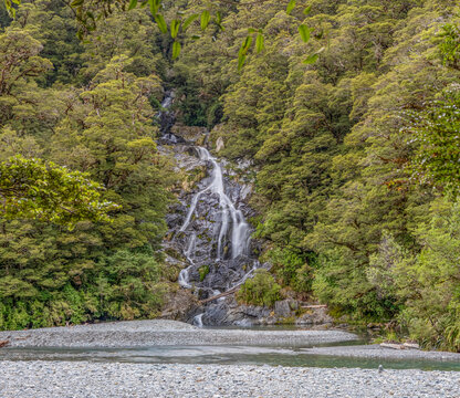 Fantail Falls, Mount Aspiring National Park, Haast Pass, kaskadenartiger Wasserfall ueber Felsstufen im dichten Regenwald, Kiesbett des Haast River im Vordergrund, Suedinsel, Neuseeland