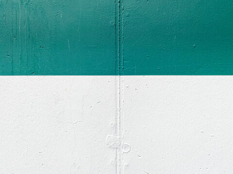 Verputzte Wand mit Fuge und Bohrl&ouml;chern in den Farben gr&uuml;n und wei&szlig; als Hintergrund mit Textfreiraum