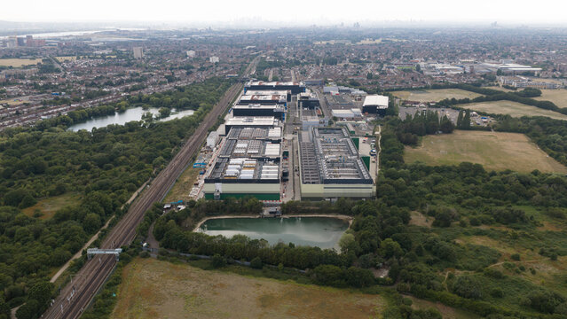 Aerial view of the NTT LON1B Data Centre surrounded by industrial buildings, railway tracks, and green spaces in Dagenham, England, United Kingdom.