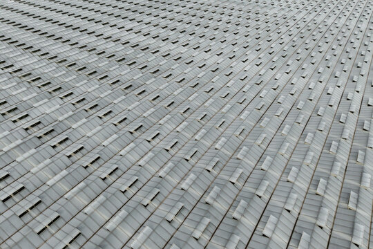 Aerial view of a large greenhouse roof featuring repetitive glass panel patterns and ventilation vents in Krakow, Lesser Poland Voivode, Poland.