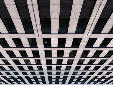 Aerial view of the modern building facade featuring repetitive window patterns and stone cladding in Krakow, Lesser Poland Voivode, Poland.
