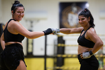 Fototapeta premium Two Women Boxers Fist Bump After Training Session in Gym Showing Friendship and Fitness