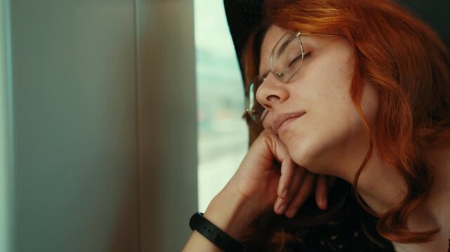 Red haired woman sleeping on a train, lying across the seat