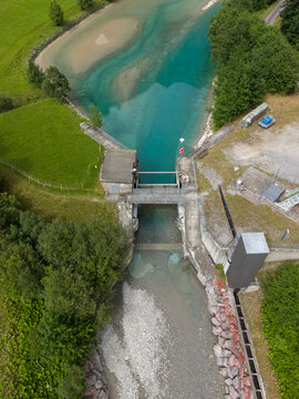 Aerial view of a water management structure regulating turquoise glacial water in the Swiss Alps near Gadmen, Switzerland.