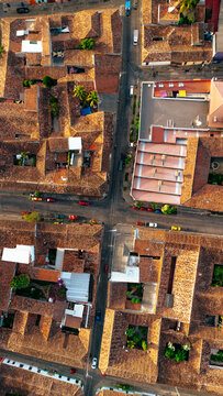 Aerial view of the historic colonial town with red-tiled rooftops, narrow streets, and inner courtyards illuminated by warm golden hour light in Suchitoto, Cuscatlan Department, El Salvador.