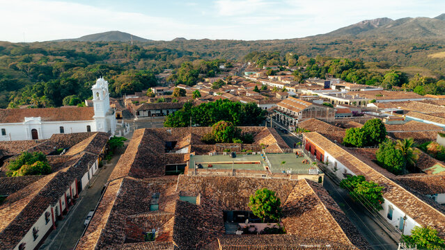 Aerial view of the historic town of Suchitoto with its iconic white church and red-tiled rooftops nestled among lush hills in Suchitoto, Cuscatlan Department, El Salvador.