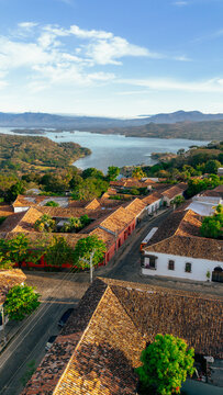 Aerial view of the colonial town of Suchitoto with red-tiled roofs, cobblestone streets, and lush greenery overlooking Suchitlan Lake in Suchitoto, Cuscatlan Department, El Salvador.