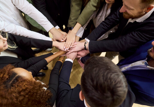 Business team people hands unity teamwork collaboration. Top view of a diverse team stacking palms in a circle to express cooperation and support in office. Clear symbol of unity and teamwork.