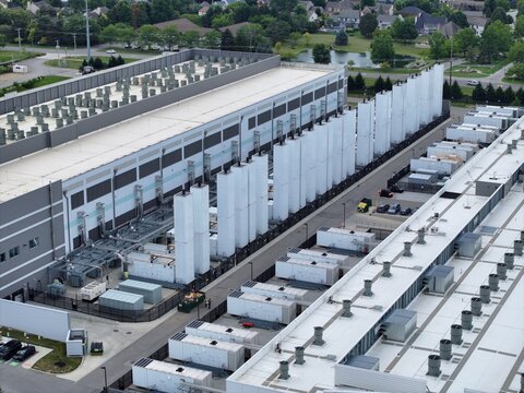 Aerial view of a large data center facility with rows of cooling units and HVAC systems on the rooftop in the United States.