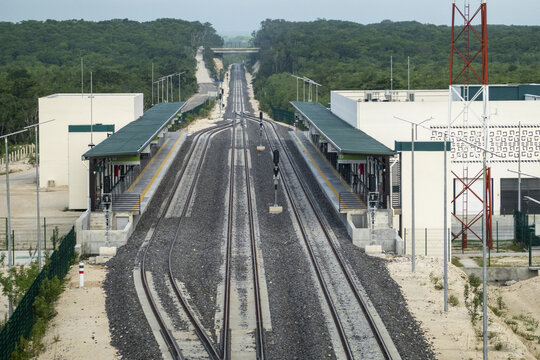 View of the modern Tren Maya station in Calakmul, featuring railway tracks, platforms with green roofs, and surrounding jungle in Calakmul, Campeche, Mexico.