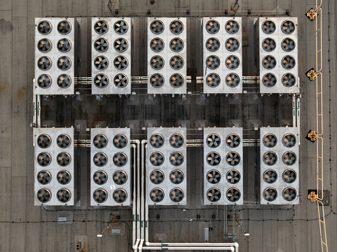 Aerial view of a data center rooftop featuring rows of industrial cooling fans and ventilation systems in Cambridge, Massachusetts, United States.