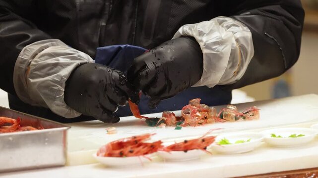 Chef Peeling Fresh Raw Shrimp for Sushi Preparation in Tokyo