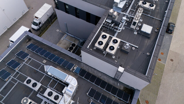 Aerial view of modern data center rooftop with HVAC cooling units and solar panels for cloud computing infrastructure, technology, and green energy.