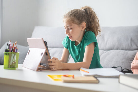 Schoolgirl using digital tablet for online learning at home