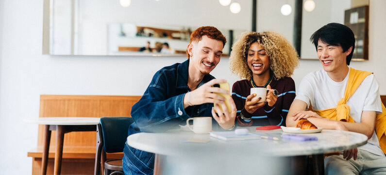 Friends enjoying coffee together in bright cafe
