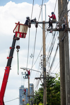 Rear view of Electrician Worker Climbing High Power Pole for Maintenance Work