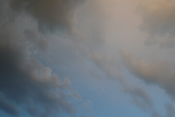 Fototapeta premium Dramatic sky with soft evening clouds and warm sunset light in summer landscape